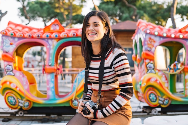 Foto grátis garota com câmera na frente de um passeio