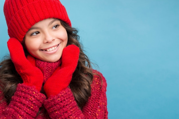 Garota com roupas de inverno vermelho, olhando para a esquerda