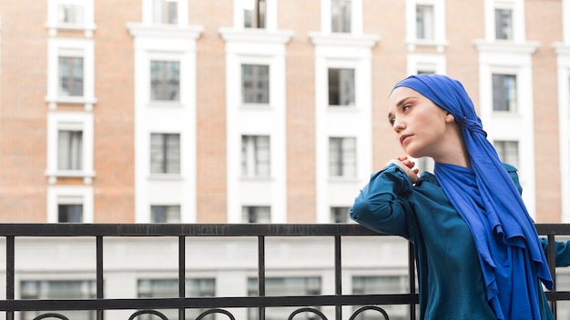 Foto grátis garota com vista lateral usando um hijab com espaço de cópia