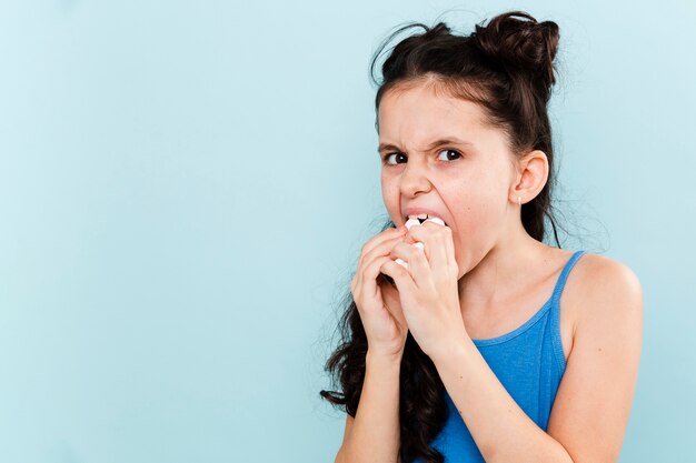 Garota comendo tudo de uma vez com cópia-espaço