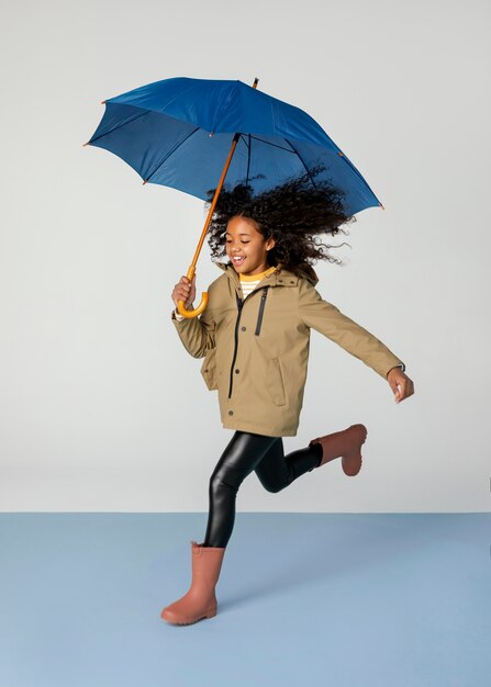 Garota completa correndo com guarda-chuva