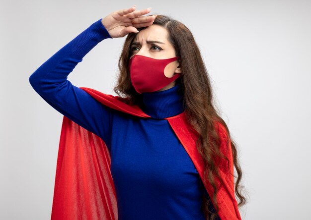 Garota confiante super-heroína caucasiana com capa vermelha e máscara protetora vermelha