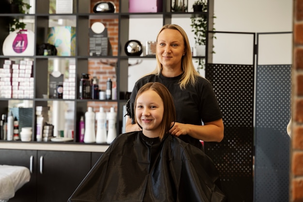 Foto grátis garota cortando o cabelo no salão de tiro médio