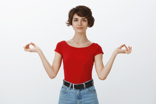 Garota de cabelo curto posando de camiseta vermelha