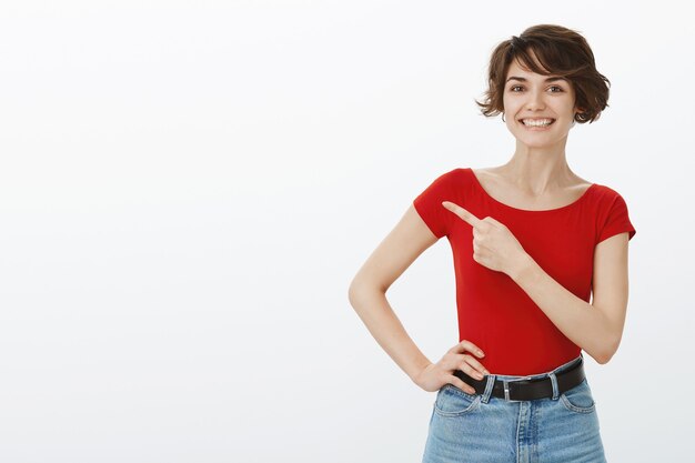 Garota de cabelo curto posando de camiseta vermelha