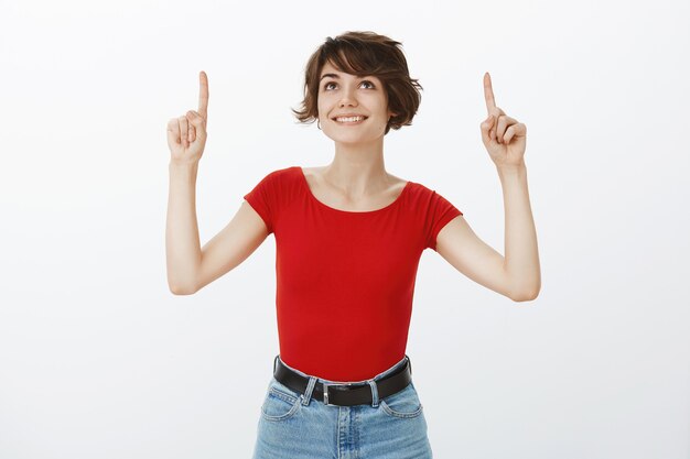 Garota de cabelo curto posando de camiseta vermelha