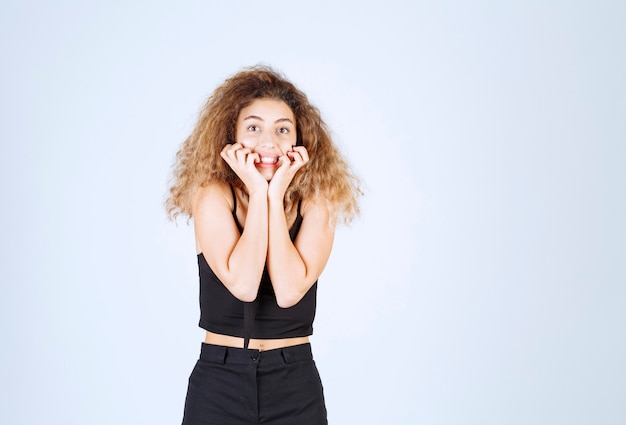 Foto grátis garota de cabelo encaracolado dando poses desagradáveis e positivas.