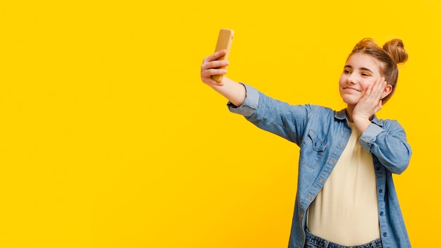 Garota de cópia-espaço tomando selfie