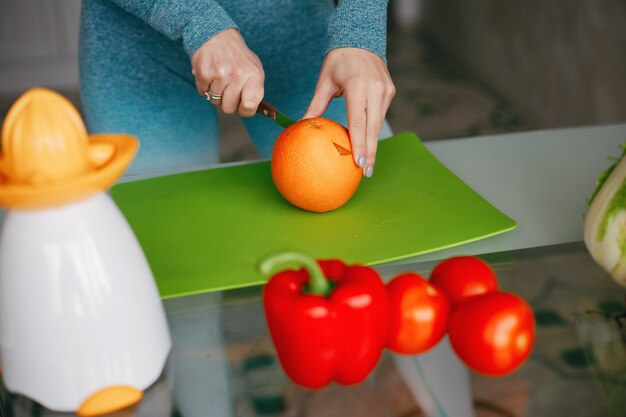 Garota de esportes em uma cozinha com legumes