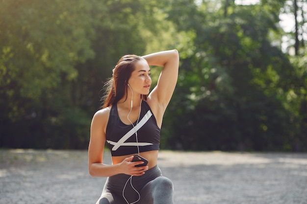 Garota de esportes treinando com telefone e fones de ouvido