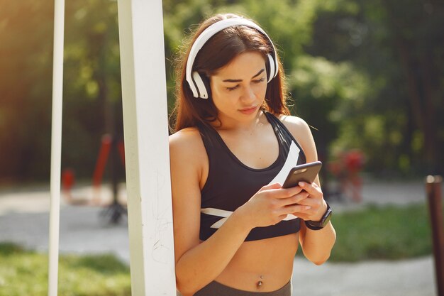 Garota de esportes treinando com telefone e fones de ouvido