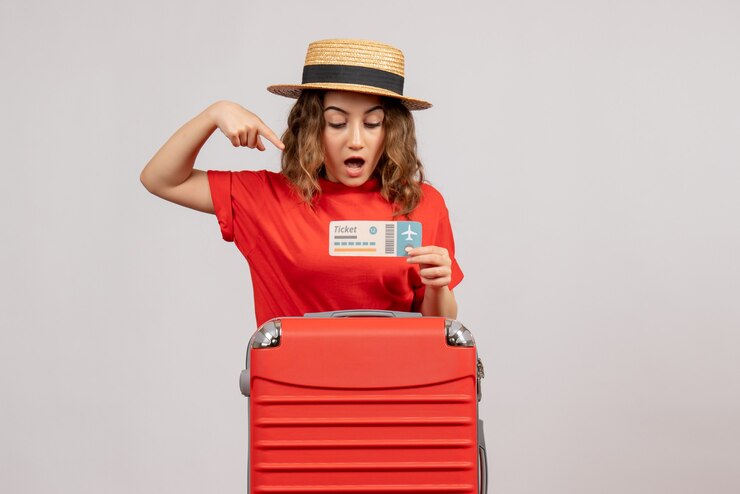 Foto grátis garota de férias imaginou com sua valise apontando para a passagem