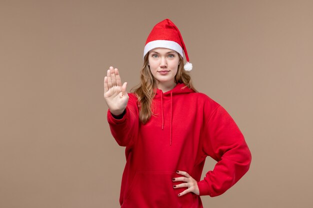 Garota de natal de frente pedindo para parar no modelo de fundo marrom feriado natal