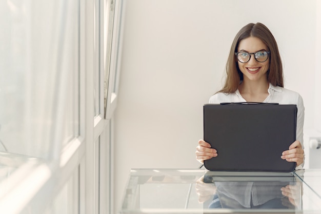 Garota de pé no escritório com um laptop