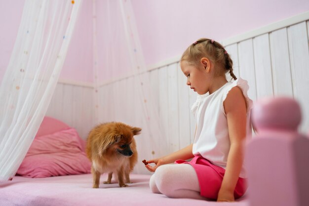 Foto grátis garota de tiro completo brincando com cachorro