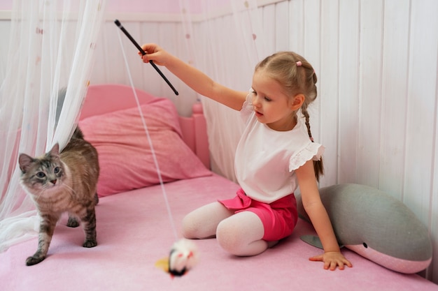 Foto grátis garota de tiro completo brincando com gato