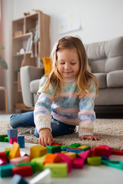 Garota de tiro completo brincando em casa