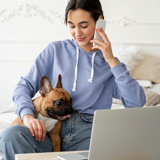 Foto grátis garota de tiro médio com telefone e cachorro