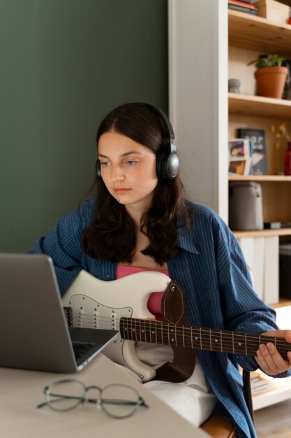 Garota de tiro médio fazendo música dentro de casa