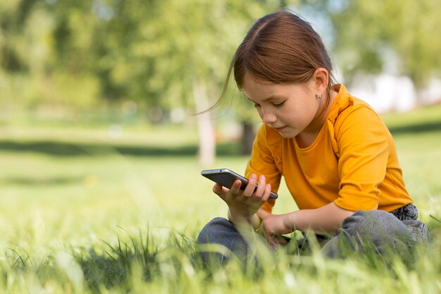 Foto grátis garota de tiro médio segurando um smartphone