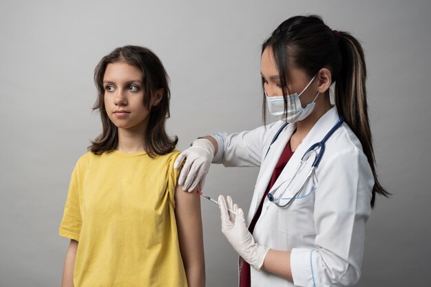Garota de tiro médio sendo vacinada