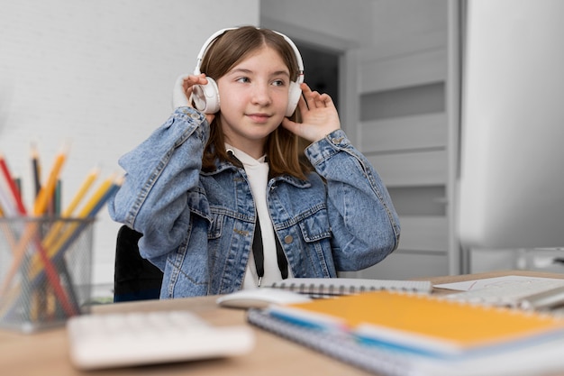 Garota de tiro médio usando fones de ouvido