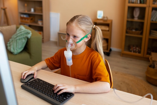 Garota de tiro médio usando nebulizador