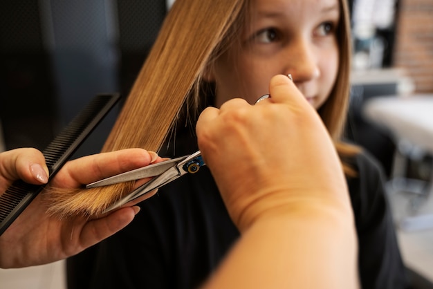 Foto grátis garota de vista lateral cortando o cabelo no salão
