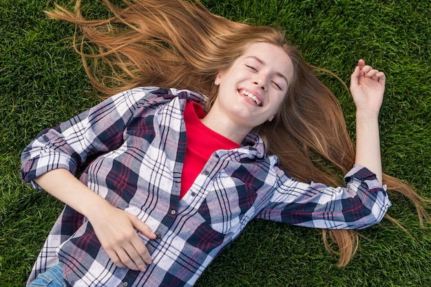 Foto grátis garota de vista superior sorridente ficar na grama