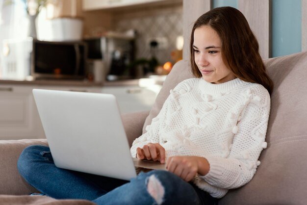 Garota em casa com laptop