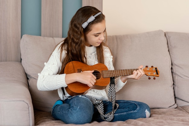 Garota em casa tocando violão