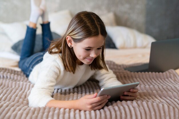 Garota em cena completa segurando o tablet