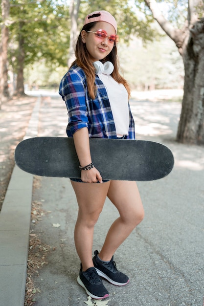 Foto grátis garota em cena completa segurando um skate