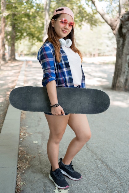 Garota em cena completa segurando um skate