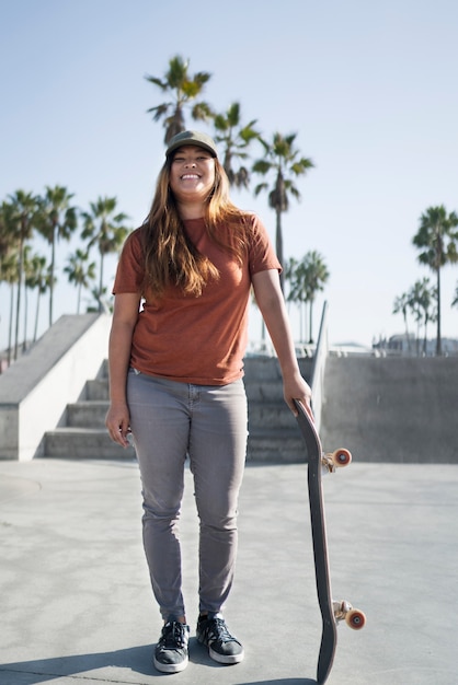 Garota em cena completa segurando um skate