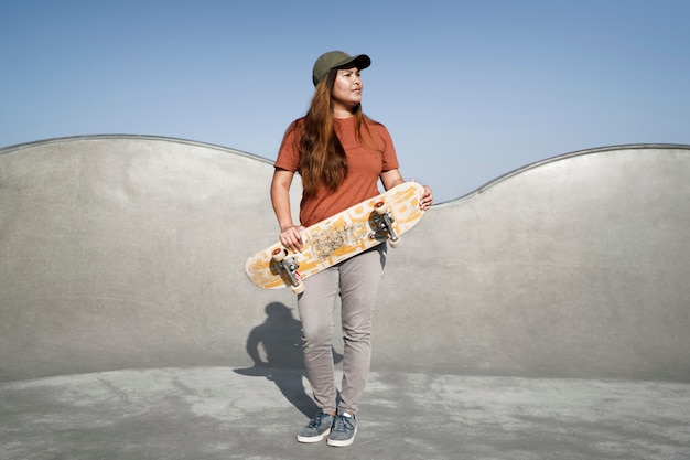 Foto grátis garota em cena completa segurando um skate