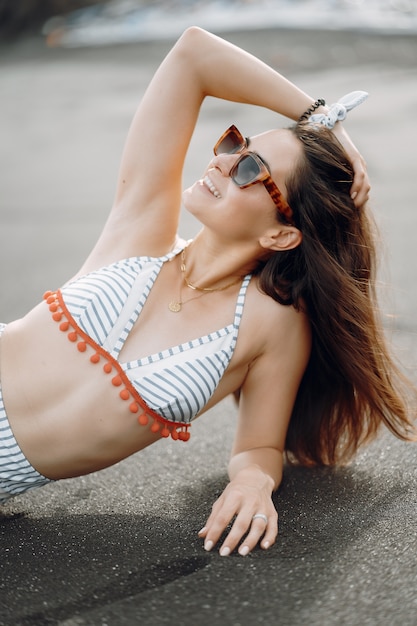 Garota em um elegante maiô tem um descanso na praia