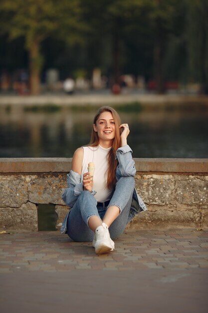 Garota em uma jaqueta jeans azul em uma cidade de verão