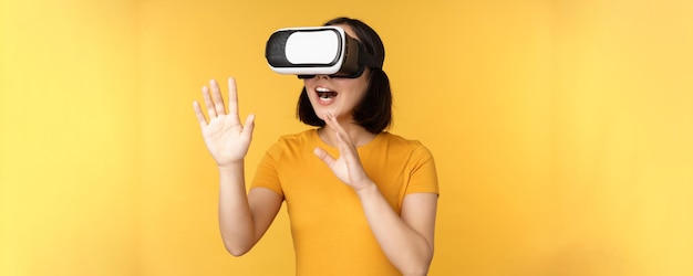 Garota em vr bela jovem asiática usando óculos de realidade virtual e jogando conversando virtualmente