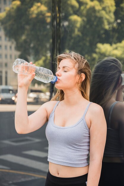 Garota esportiva bebendo água
