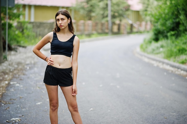 Garota esportiva em roupas esportivas se exercitando em um parque verde e treinando na natureza Um estilo de vida saudável