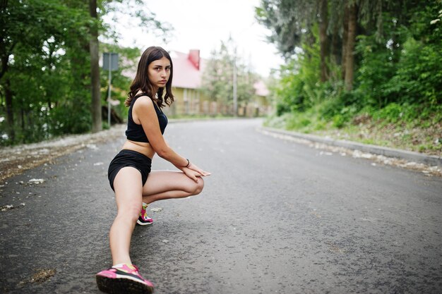 Garota esportiva em roupas esportivas se exercitando em um parque verde e treinando na natureza Um estilo de vida saudável