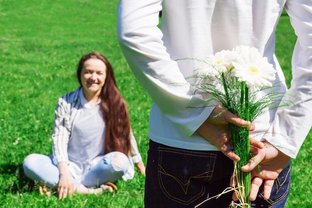 Garota está segurando flores ao lado das costas concepção de presente
