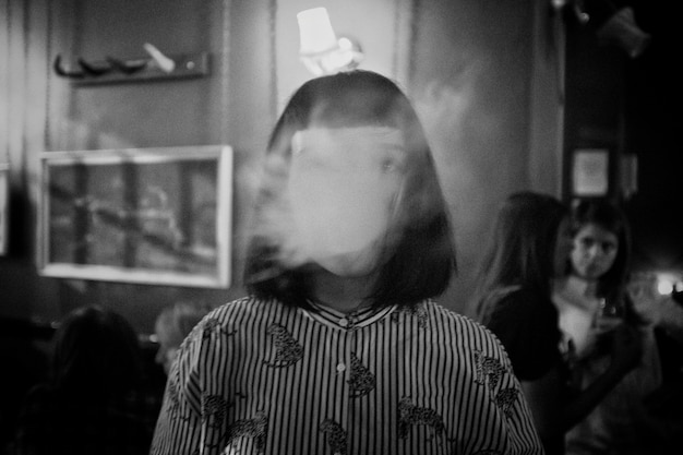 Foto grátis garota fazendo fumaça com a boca