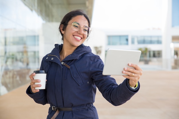 Garota feliz animada, desfrutando de café e chamada de vídeo