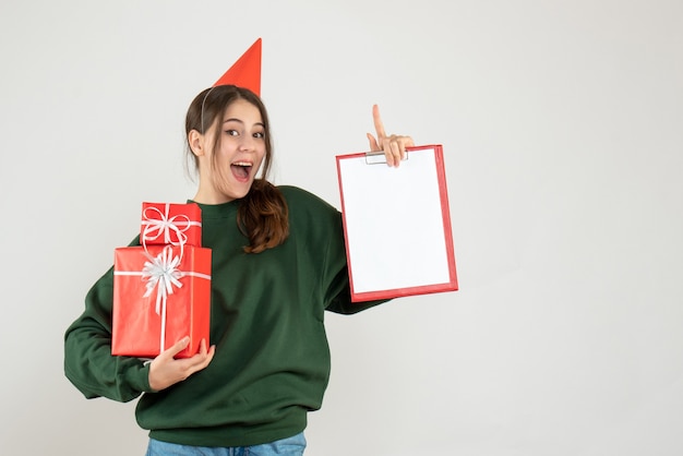 Garota feliz com boné vermelho de pé no branco