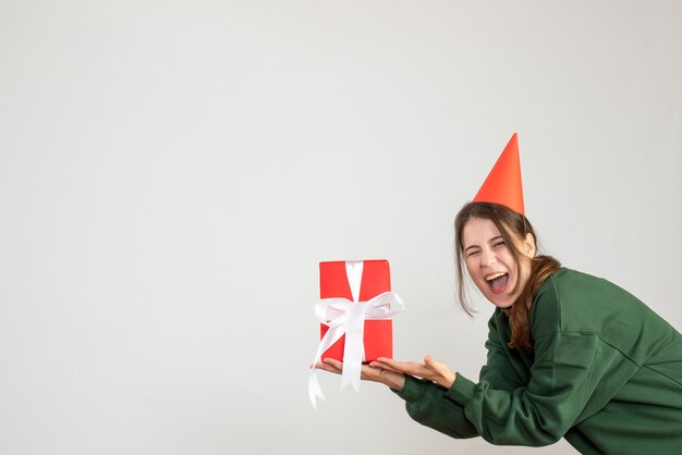 garota feliz com chapéu de festa segurando seu presente em branco