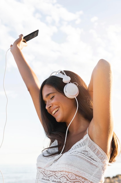 Garota feliz com fones de ouvido ao ar livre