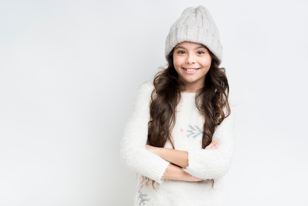 Garota feliz com roupas de inverno e mãos cruzadas