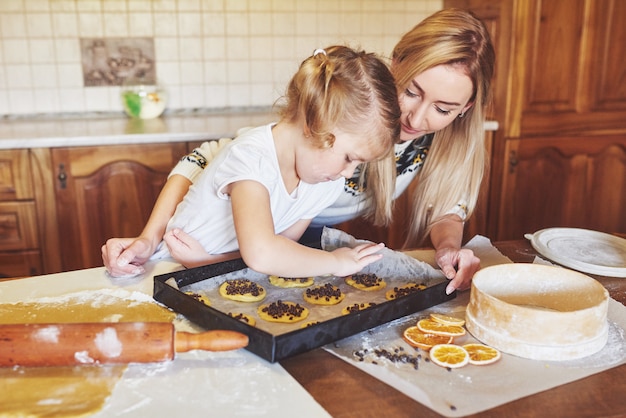 Garota feliz com sua mãe cozinhar biscoitos.